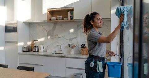 Profissional de limpeza a higienizar vidro num espaço moderno