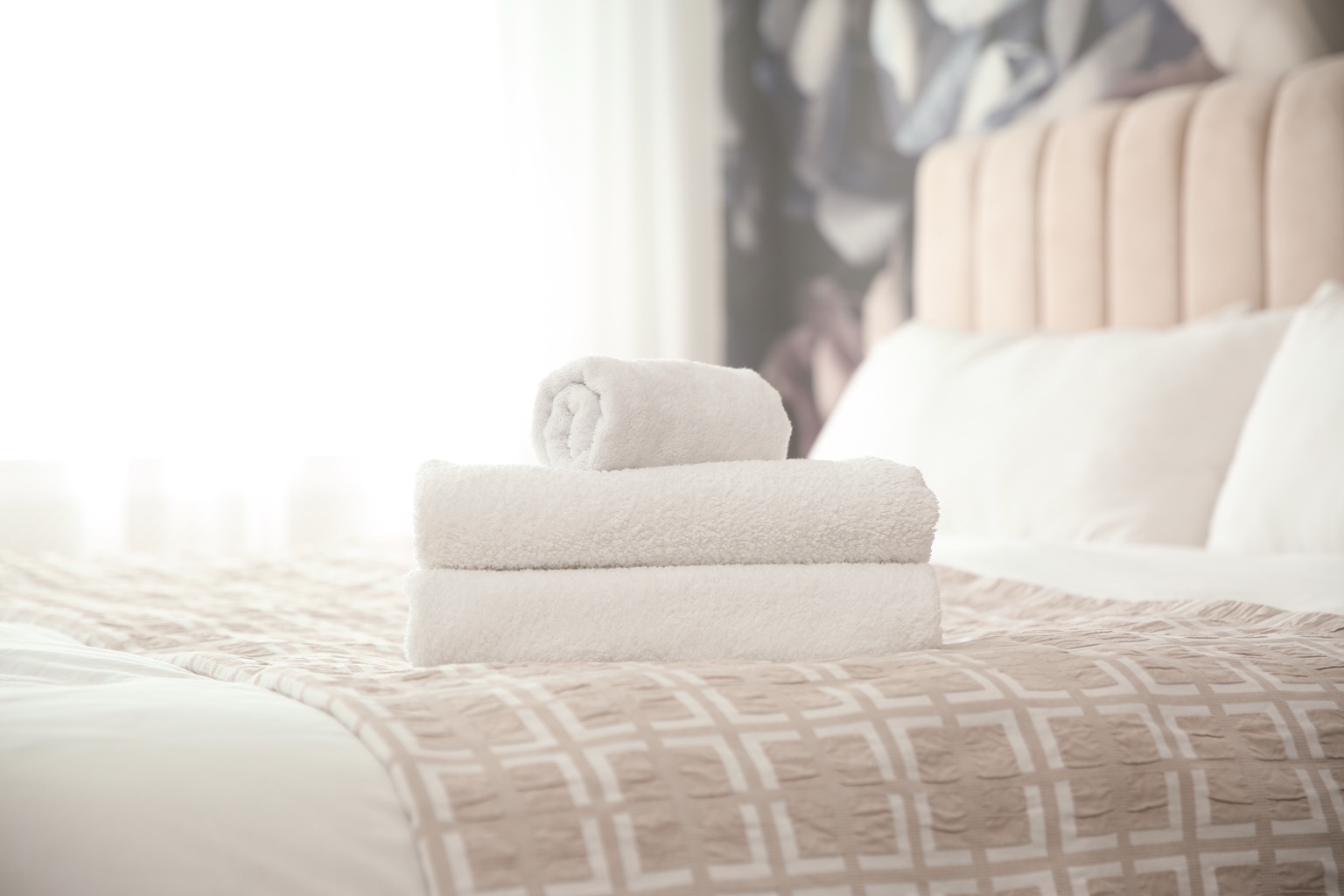 Cama de alojamento local preparada para check-in no Porto, com toalhas limpas e roupa de cama organizada.