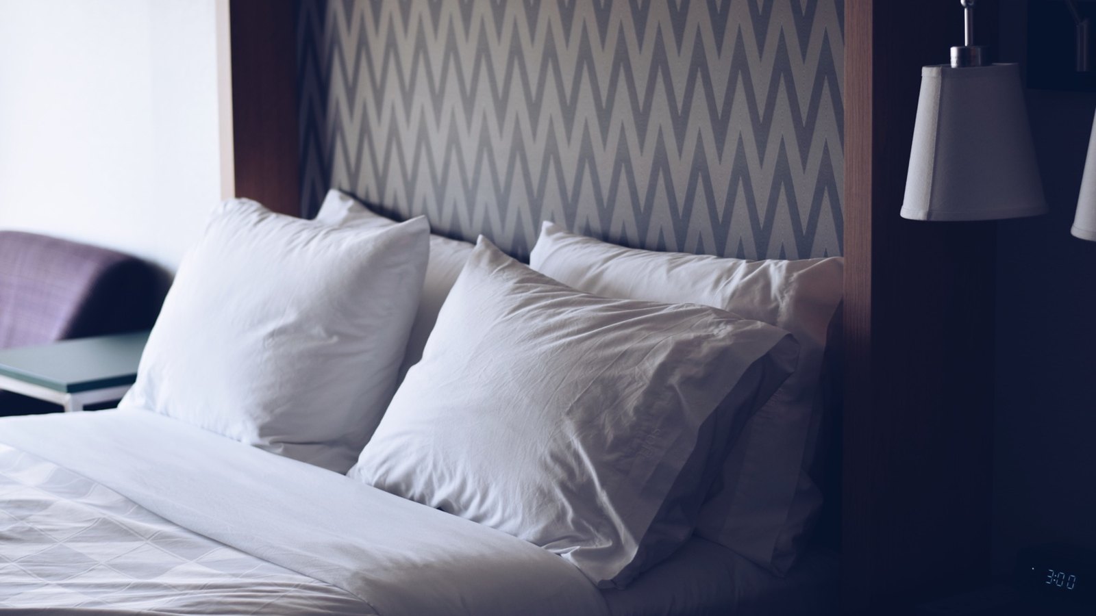 Quarto de hotel preparado com cama alinhada para receber hóspedes no Porto