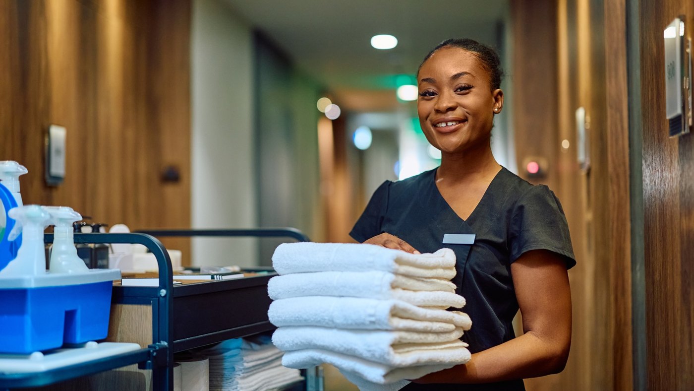 Equipa de housekeeping com toalhas limpas em operação hoteleira