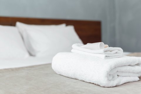 Quarto de hotel no Porto pronto para receber hóspede com cama alinhada e têxteis cuidados