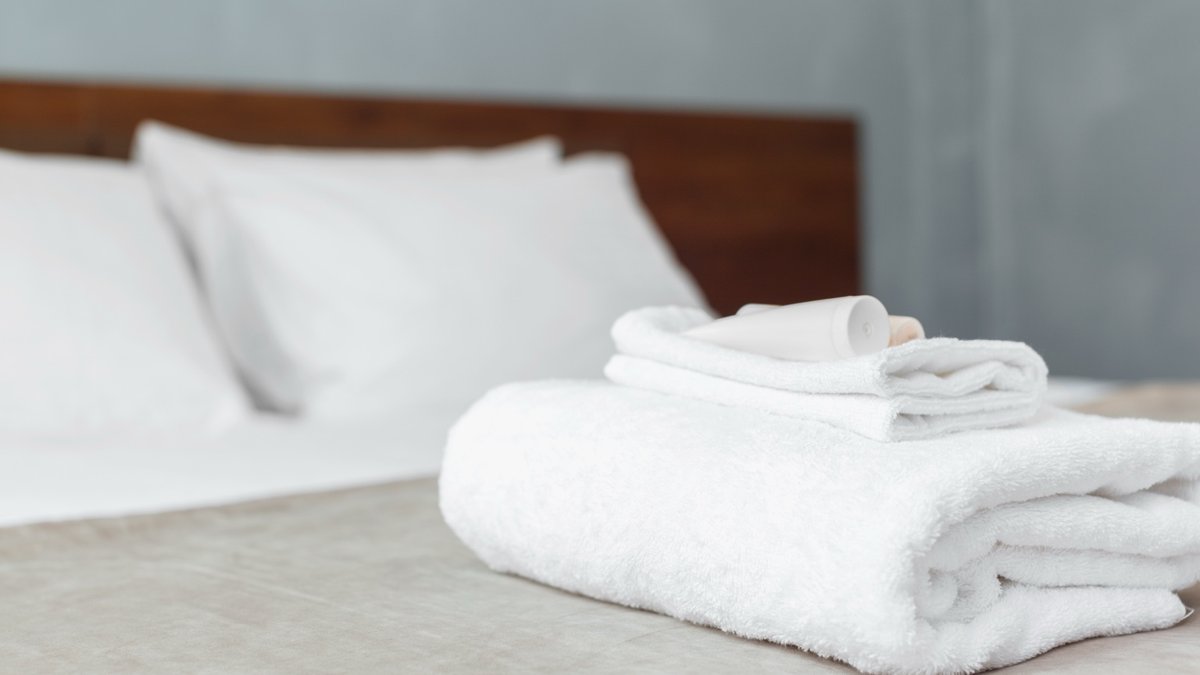 Quarto de hotel no Porto pronto para receber hóspede com cama alinhada e têxteis cuidados
