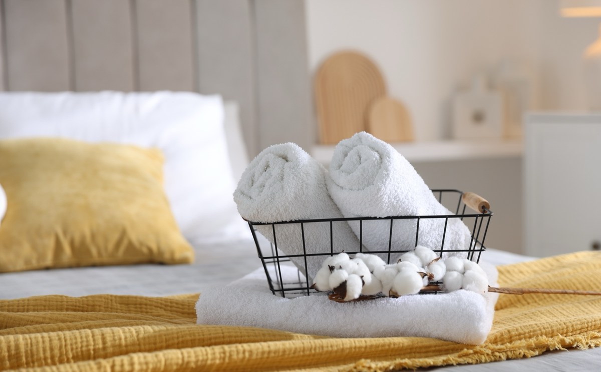 Cama de Alojamento Local preparada com toalhas para receber o próximo hóspede